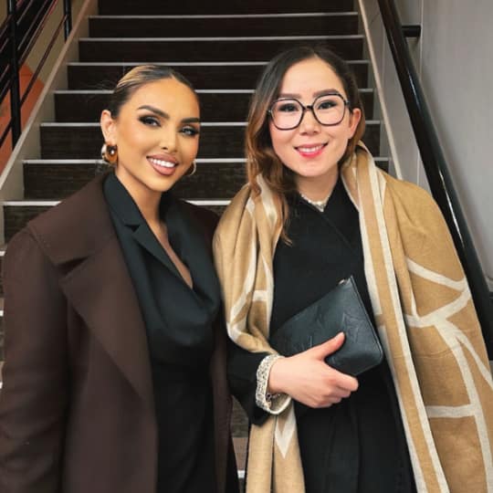 2 women at bottom of stairs looking sharp.