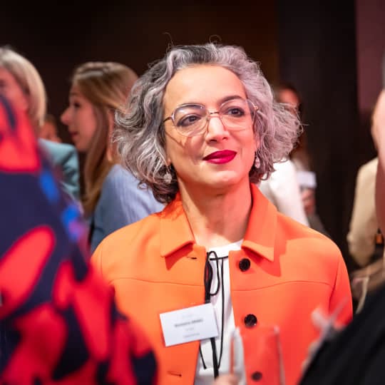 Women President of a company in orange.