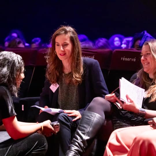3 woman talking together to prepare a panel.
